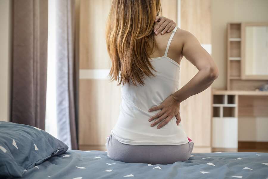 woman-suffering-from-back-ache-bed-min-1